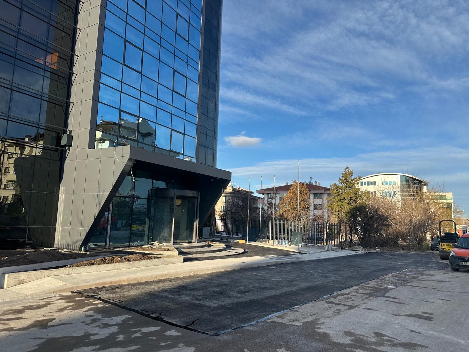 Kurumsal bina girişi asfalt, cam cephe ve Bomag, Ankara
